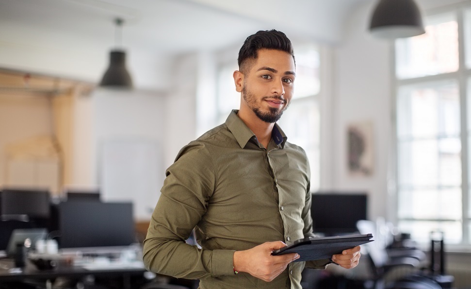 A man holding a tablet in an office