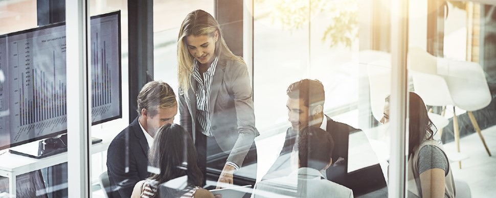 6 office workers sitting around a table in an office setting