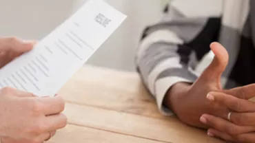 Person holding a resume during a job interview.