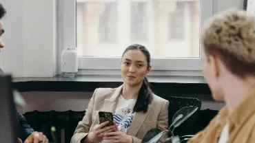 Three colleagues having a discussion in a modern office.